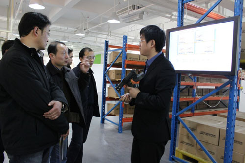 利奥创新科技工作人员正在向吴肇明处长等人讲解RFID二维仓库系统的功能特点