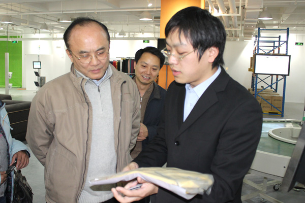 利奥创新科技工作人员向张建副局长介绍RFID智能标签在服装产业链上的应用优势